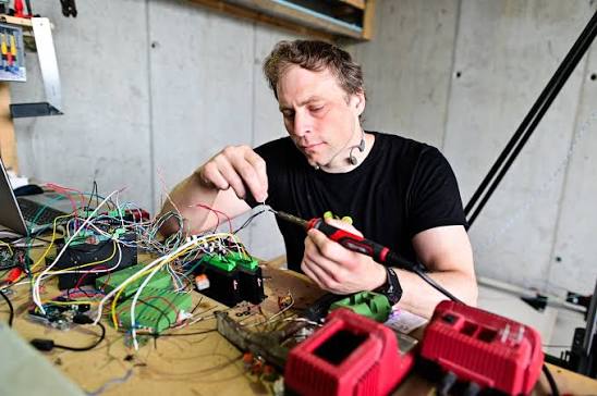 Jesper Tveit soldering electronics at the workshop bench
