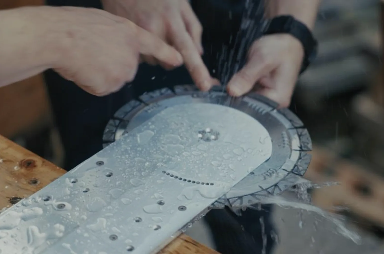 Wet prototype diamond blade and cutting head, with hands pointing at the assembly