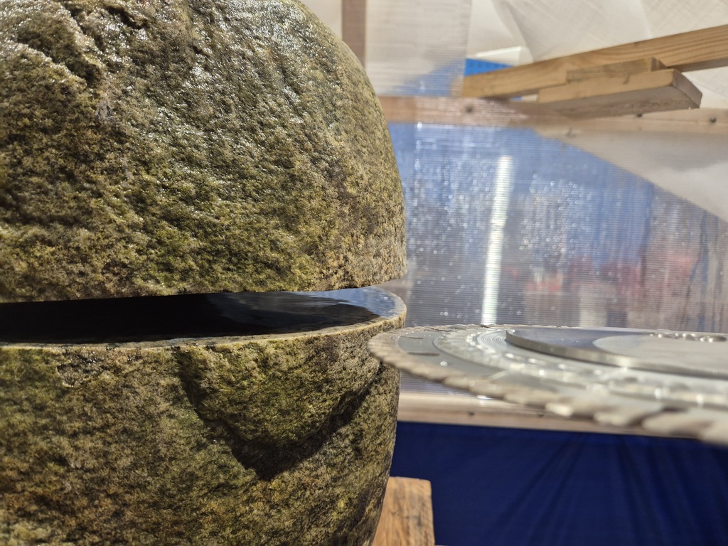 En steinblokk delt av et smalt, rett spor, med et diamantblad fra en prototype ved siden av