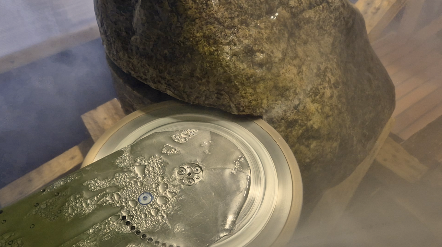 Prototype blade cutting into a boulder, water spraying from the cut